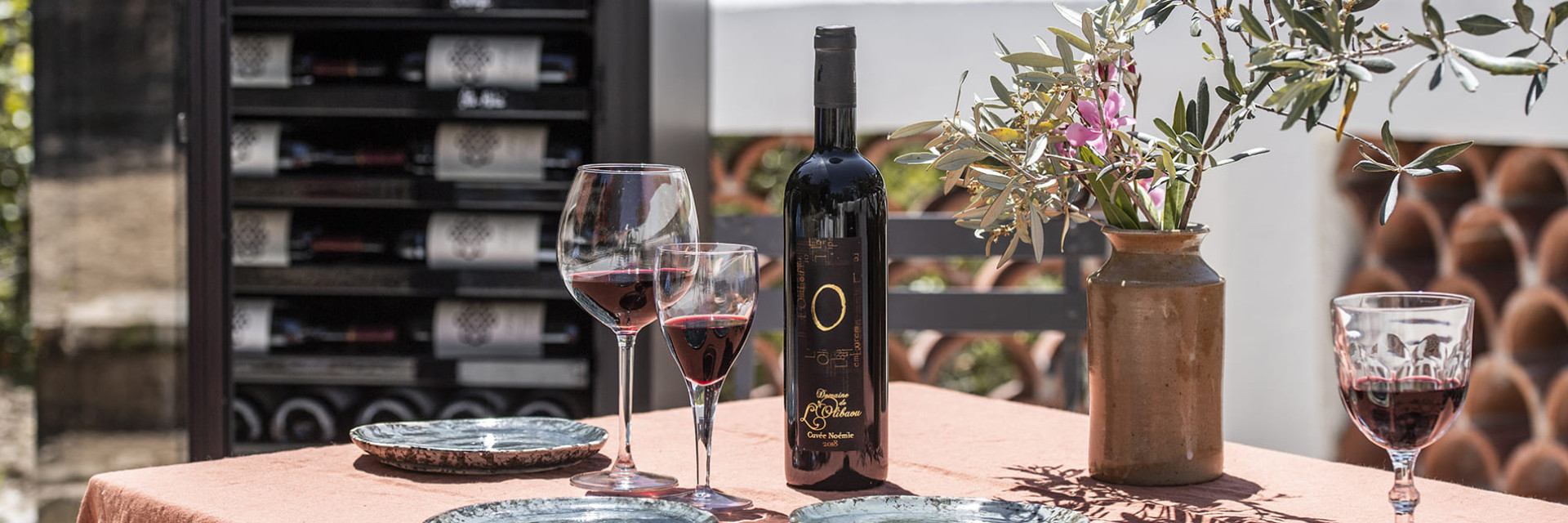 Ein wunderschön gedeckter Tisch auf der Terrasse, ein gutes Essen und eine gute Flasche Wein; um sich gut zu empfangen oder einen romantischen Moment zu teilen. Ein wunderschön gedeckter Tisch auf der Terrasse, ein gutes Essen und eine gute Flasche Wein; um sich gut zu empfangen oder einen romantischen Moment zu teilen.