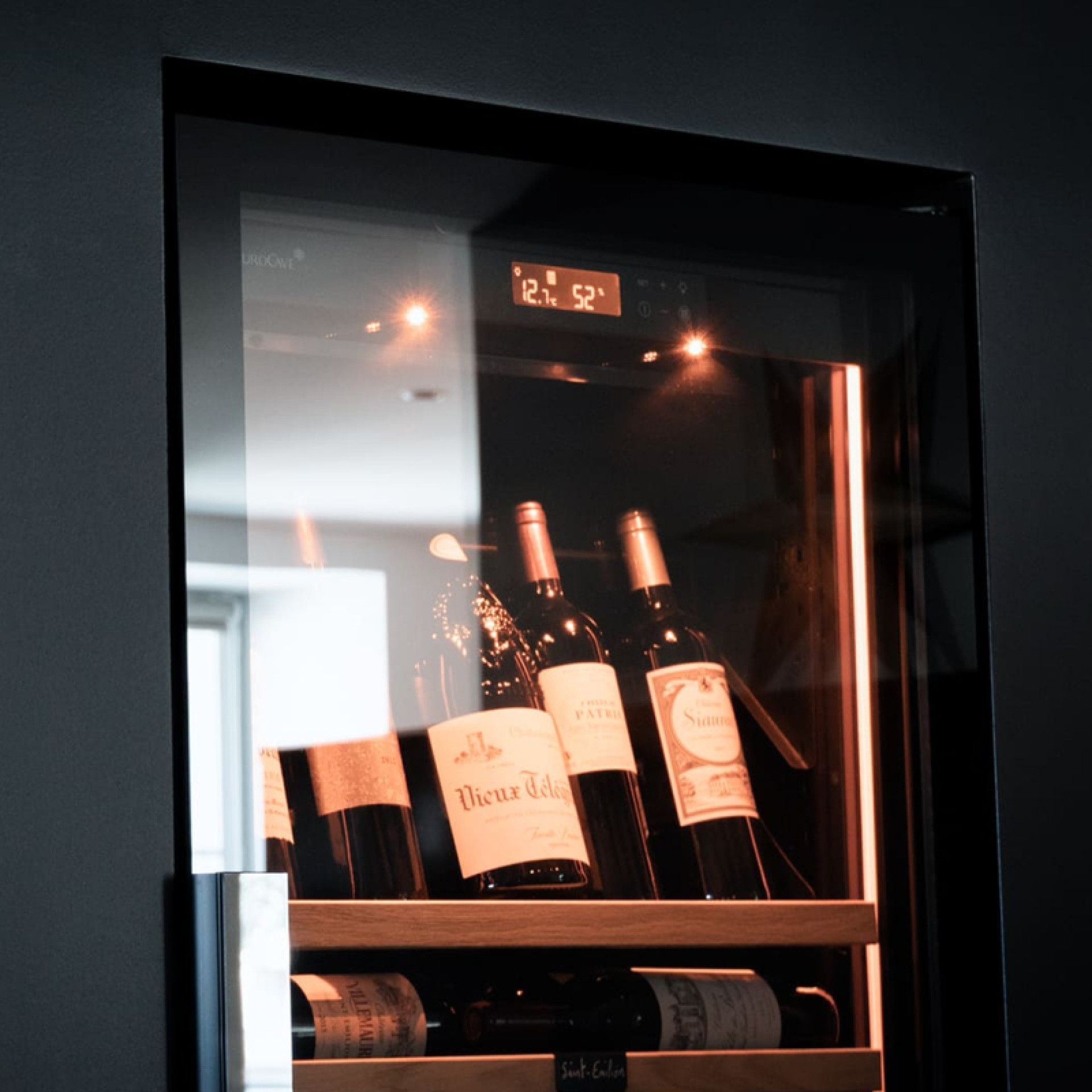 Une porte totalement vitrée sans cadre pour des lignes épurées et une vue dégagée sur vos plus belles bouteilles de vin.