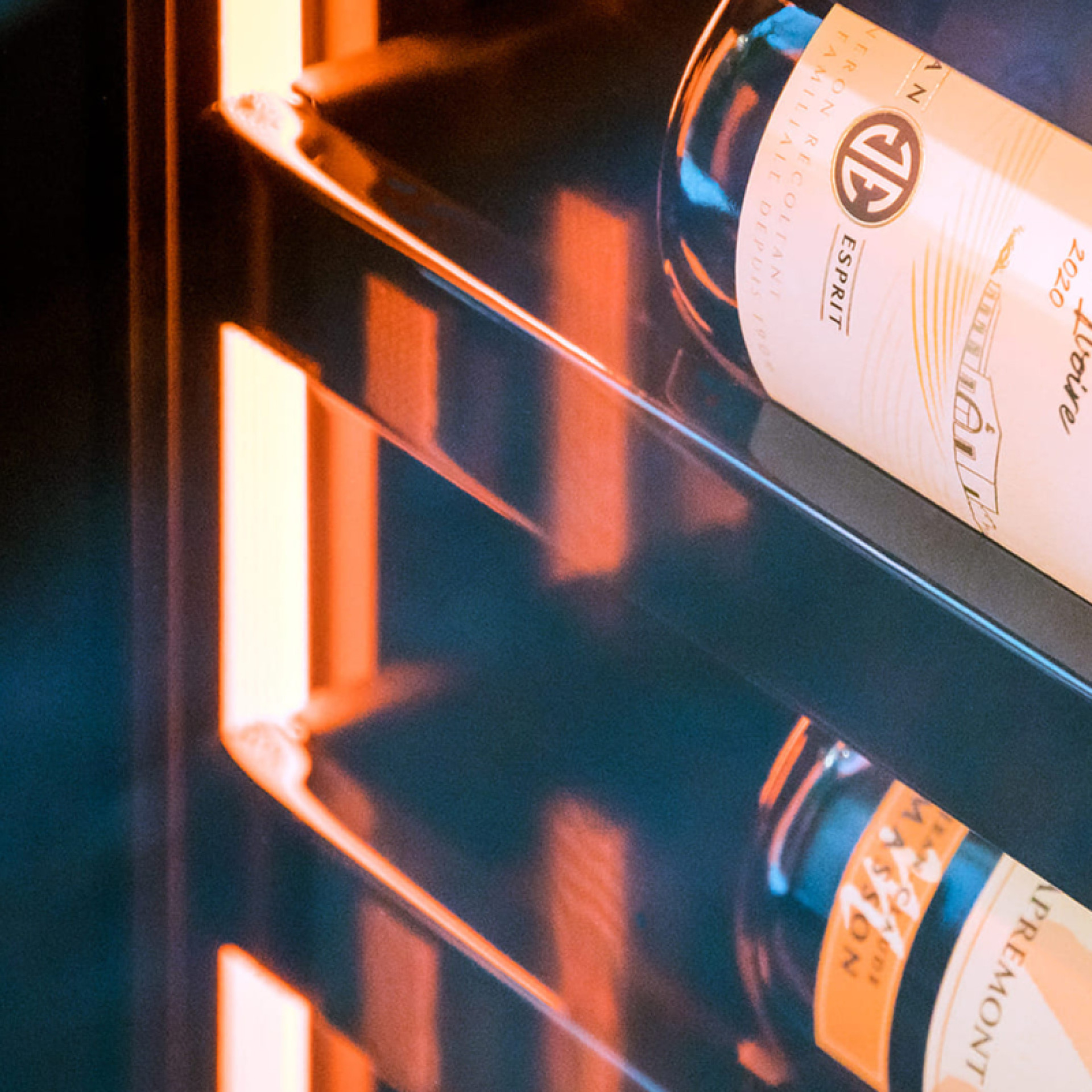 Der leuchtende Heiligenschein, der sich durch den gesamten Weinkhülschrank zieht, zieht die Blicke durch die schöne Hervorhebung der Weinflaschen auf sich.