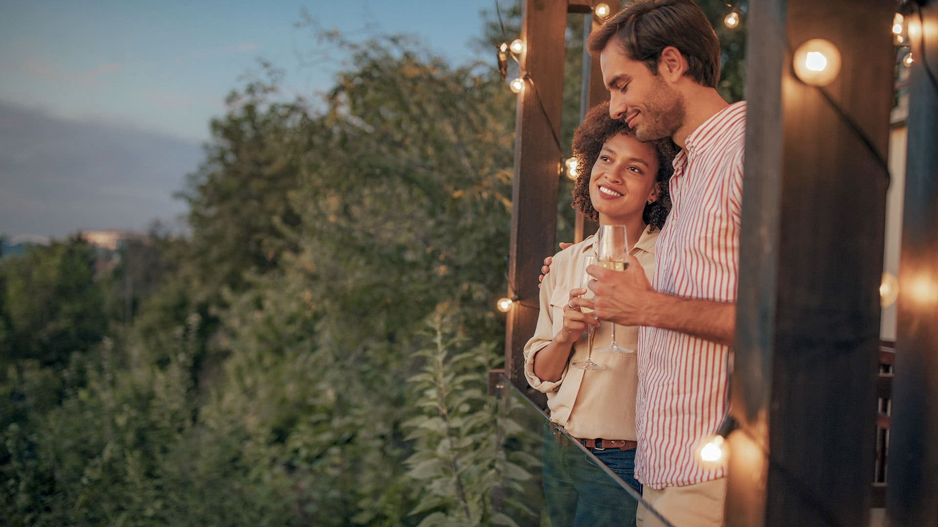 Ein Paar beim Aperitif bei Sonnenuntergang und einem Glas Wein auf der Terrasse, ein Moment purer Romantik.
