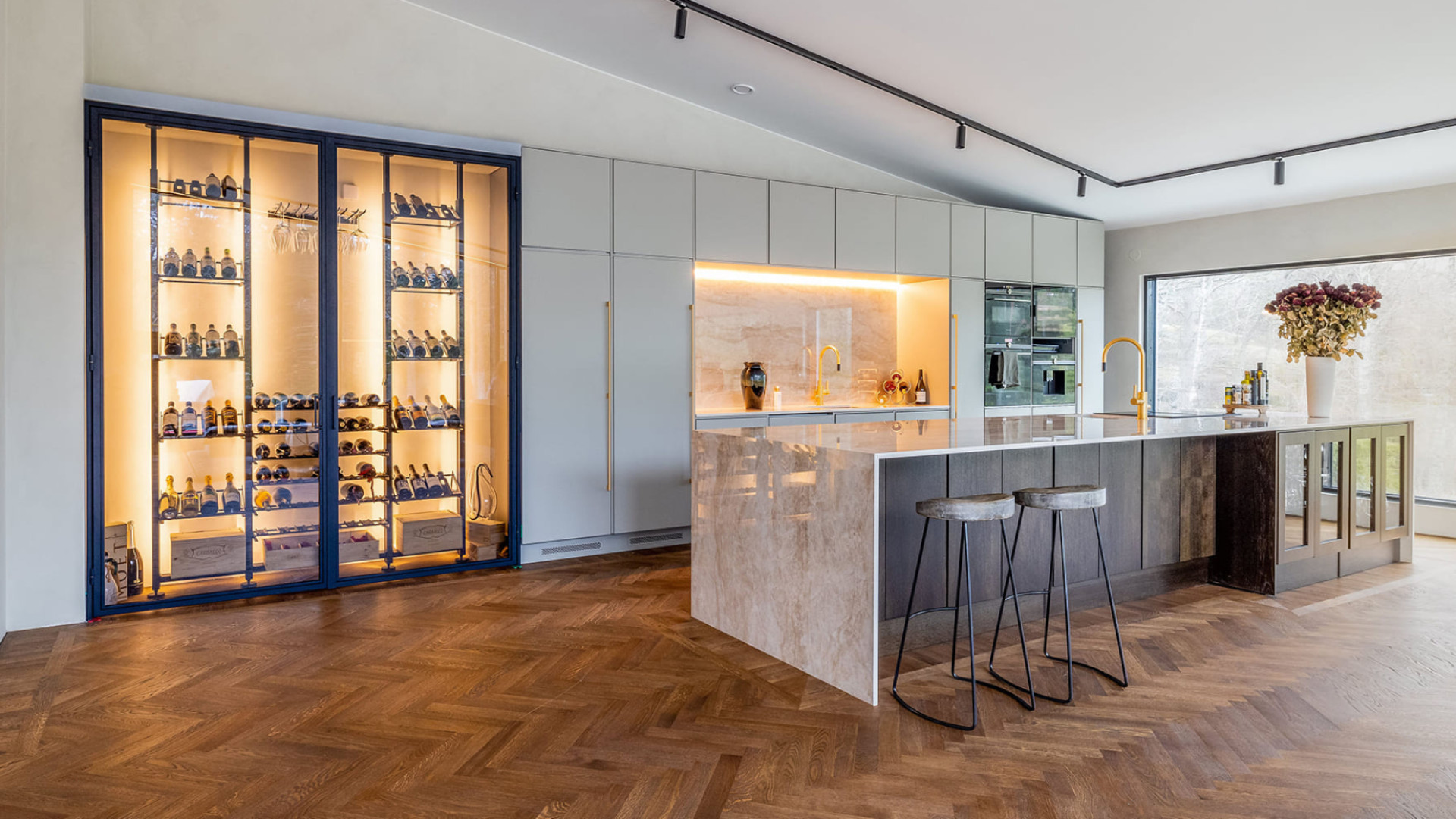 Traumweinkeller – Beispiel für die Gestaltung einer in die Wand eingebauten Weinvitrine eines modernen und luxuriösen Innenraums mit einer Kücheninsel aus Marmor. Traumweinkeller – Beispiel für die Gestaltung einer in die Wand eingebauten Weinvitrine eines modernen und luxuriösen Innenraums mit einer Kücheninsel aus Marmor.