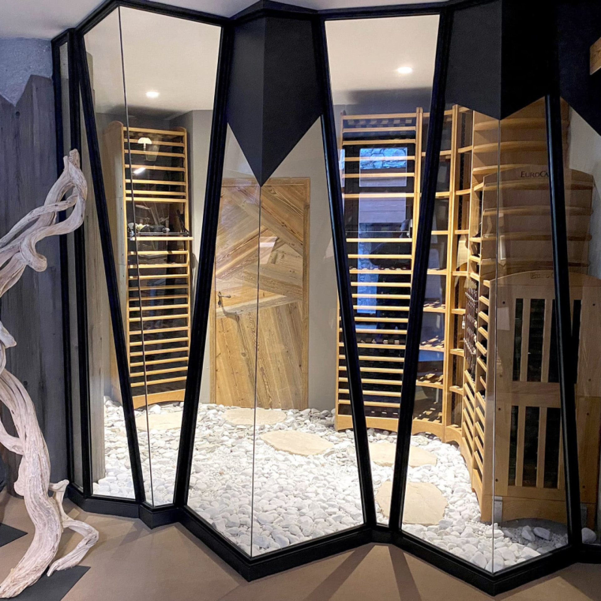 Conception d'une cave à vin de rêve mêlant la tradition et l'authenticité des meubles de menuisier en bois massif de fabrication française et le design moderne de la pièce climatisée.