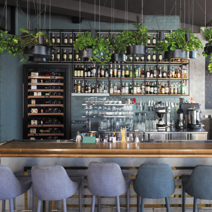 Cave à vin pro avec échelonnement de température installée derrière le bar pour des vins rouges, blancs ou rosés à portée de main, prêts à servir.