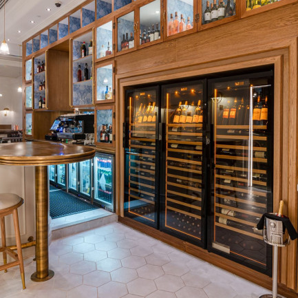 3 caves professionnelles avec éclairage intégré de série dans un meuble sur-mesure en bois pour une belle valorisation de la carte des vins dans ce restaurant.