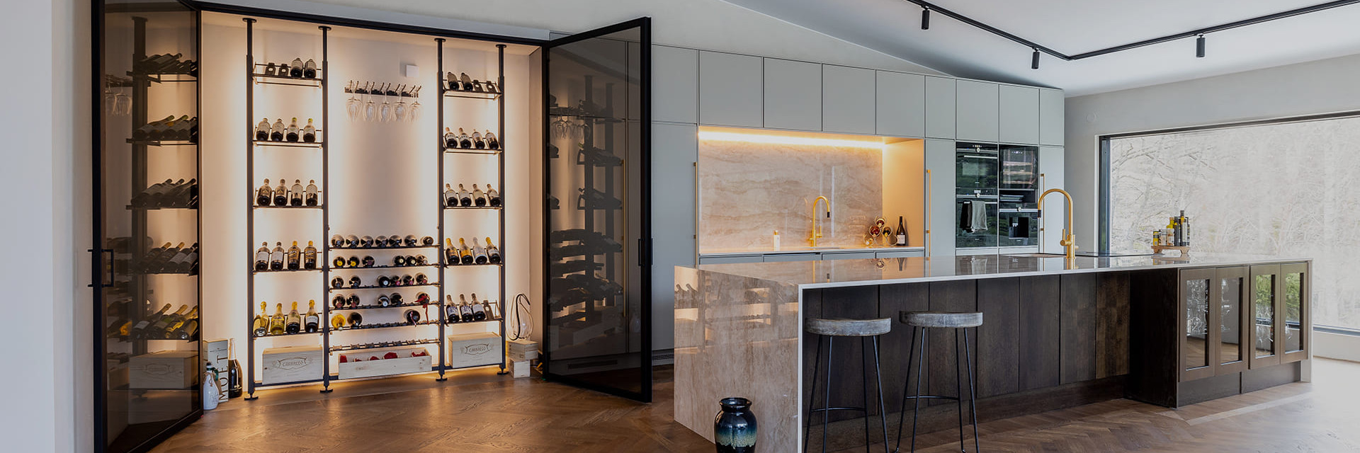  Interior design project - Layout of a custom wine cellar - wine space with black metal wine storage installed in a niche in the wall of a luxury kitchen.
