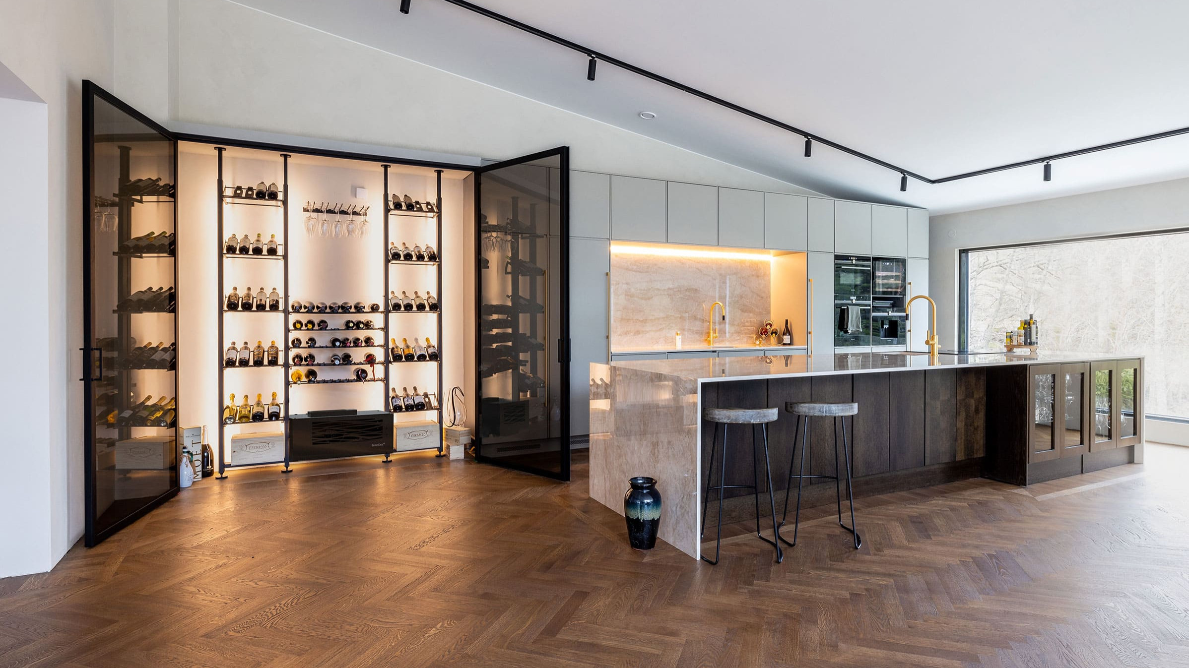 Custom air-conditioned wine area. Example of making a glass wall display case in a luxury kitchen. Elegant interior architecture.