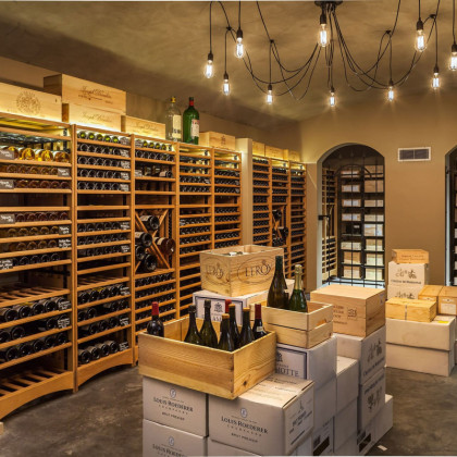 Aménagement de cave à vin traditionnelle et élégante avec le système de rangement vin en chène massif Modulothèque.