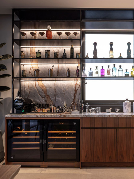 Deux caves à vin EuroCave Compact à porte vitrée, installées sous plan dans un bar, intégrées dans un mobilier en bois avec plan de travail en marbre, ambiance contemporaine élégante