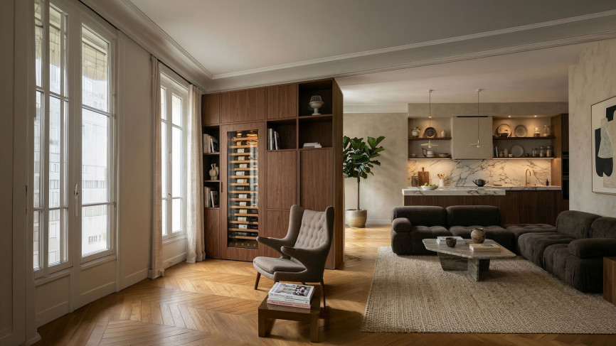 Grande cave à vin encastrable de la collection Inspiration, avec porte vitrée intégrale, parfaitement intégrée dans un meuble de salon en noyer